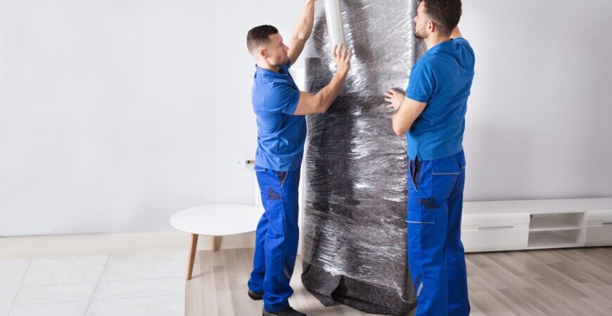 Great Toronto Movers labour only moving services. Two movers wrapping a cabinet.