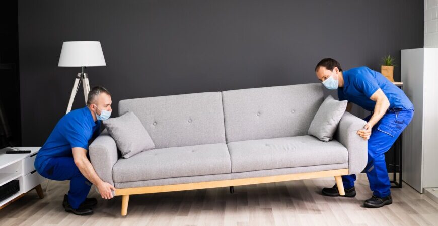 Great Toronto Movers. Professional furniture assembly services Toronto with Best-In-Class insurance. Two men placing down a sofa.
