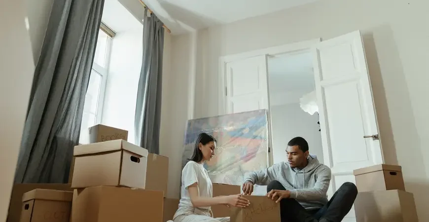 A young couple unpacking in their new condo after a seamless move with professional condo movers.